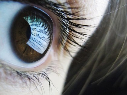 A pictures shows binary code reflected from a computer screen in a woman's eye on October