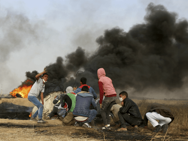 Palestinian protesters cover during clashes with Israeli troops along Gaza's border with Israel, east of Khan Younis, Gaza Strip, Thursday, April 5, 2018. An Israeli airstrike in northern Gaza early on Thursday killed a Palestinian, while a second man died from wounds sustained in last week's mass protest. The fatalities …