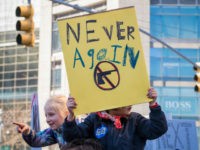 View of a young demonstrator, on someone's shoulders, as she holds a sign that reads 'Never Again' during the March For Our Lives rally against gun violence, near Columbus Circle, New York, New York, March 24, 2018. Beside her, another girl points her finger. (Photo by Barbara Alper/Getty Images)