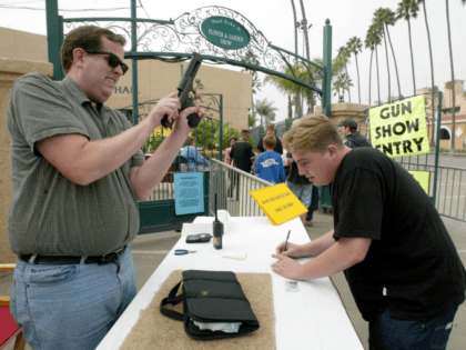 A man checks a handgun at the reception desk of the Cross Roads of the West Gun Show in Del Mar, California, 20 October, 2002, where loade guns are not allowed. The show is being held several times a year in dozens of cities in the West Coast and gathers …
