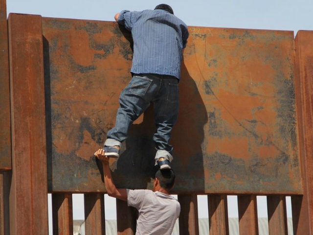 A young Mexican helps a compatriot to climb the metal wall that divides the border between Mexico and the United States to cross illegally to Sunland Park, from Ciudad Juarez, Chihuahua state, Mexico on April 6, 2018. US President Donald Trump on April 5, 2018 said he would send thousands …