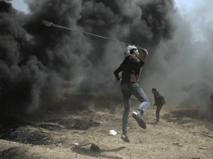 A Palestinian protester hurls stones at Israeli troops during a protest at the Gaza Strip'