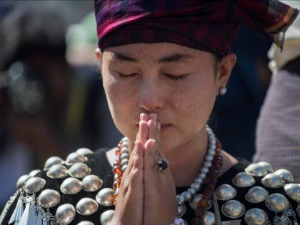 A woman wearing traditional dress from Kachin state in Myanmar sheds a tear as she prays outside St. Mary's Cathedral during a mass led by Pope Francis in Yangon during his last day of a four-day visit on November 30, 2017. Pope Francis on November 30 wrapped up a visit …