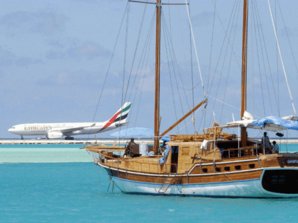 In this picture taken on October 18, 2003, An aeroplane lands at Male International Airport while a sail boat makes its way through a blue lagoon. The exotic Maldives, one of the world's most exclusive tourist destinations, is looking to cut prices and put resort expansion on hold to weather …