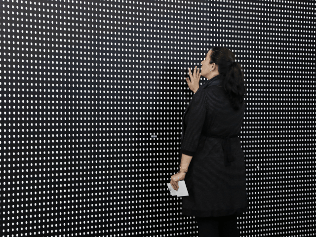 Janine Fisher of Pittsburgh looks at an art installation called "Prescribed to Death Memorial" at the William Pitt Union at the University of Pittsburgh on Wednesday, Jan. 31, 2018 in Pittsburgh. The installation features 22,000 carved medicine pills that represent the face of someone who fatally overdosed in 2015. A …