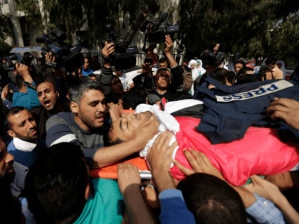 Mourners and journalists carry the body of Palestinian journalist Yasser Murtaja, during his funeral in Gaza City on April 7, 2018. Among those killed at Friday's protest was Yasser Murtaja, a photographer with the Gaza-based Ain Media agency, who died from his wounds after being shot, the local health ministry …