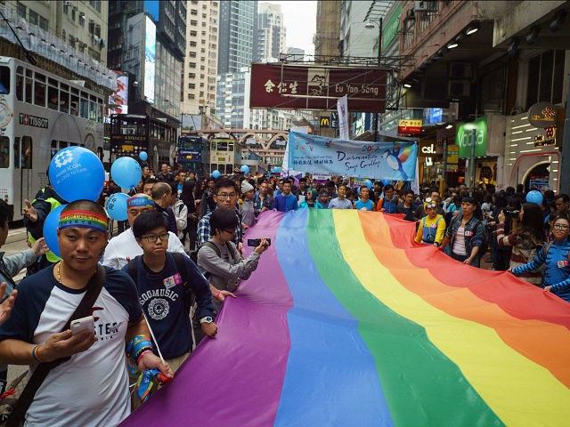 Participants of Hong Kong's annual pride parade march with a giant rainbow flag on November 25, 2017. Rainbow flags flowed through the streets of Hong Kong on November 25 during the city's annual pride parade, as LGBT activists criticised authorities for lagging behind on equal rights. / AFP PHOTO / …