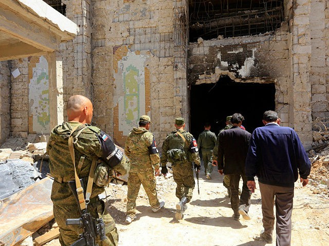 Russian forces patrol damaged buildings in Douma, Syria on the outskirts of Damascus on Ap