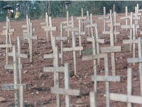 Rwandan women walk along a path next to a mass grave holding hundreds of victims of the 1994 genocide Saturday, Sept. 7, 1996 outside Kigali, Rwanda. An International Criminal Tribunal for Rwanda will begin genocide trials in Arusha, Tanzania Sept. 26, 1996. (AP Photo/David Guttenfelder)