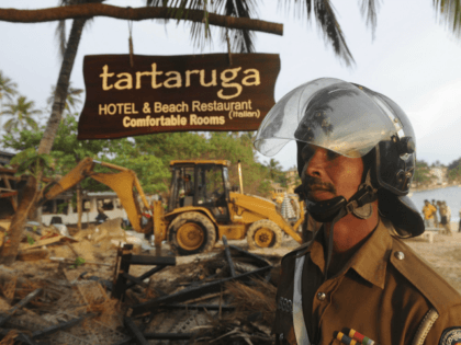 A Sri Lankan police officer looks on near a demolished illegally built Sri Lankan hotel that was bulldozed in the southern town of Unawatuna on December 13, 2011. Sri Lanka is experiencing a boom in tourism after security forces crushed the Tamil Tiger rebels in May 2009, ending 37-years of …