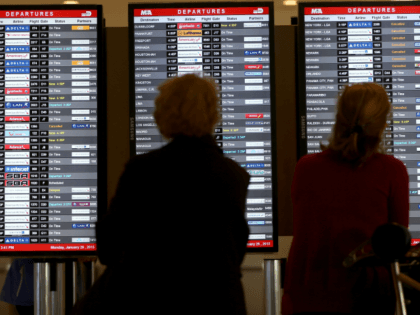 Passengers look at a departure board at Miami International Airport on January 26, 2015 in Miami, Florida. Northeast coast airports are canceling thousands of flights as a major winter storm hits the North East U.S. (Photo by Joe Raedle/Getty Images)
