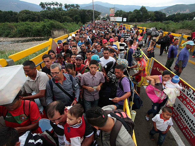 TOPSHOT - Venezuelan citizens cross the Simon Bolivar international bridge from San Antonio del Tachira in Venezuela to Norte de Santander province of Colombia on February 10, 2018. Oil-rich and once one of the wealthiest countries in Latin America, Venezuela now faces economic collapse and widespread popular protest. / AFP …
