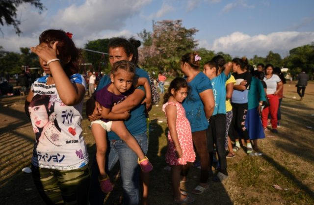 Central American migrants taking part in the Migrant Via Crucis caravan toward the United States queue for food at a sports field in Matias Romero, Mexico, on April 3, 2018