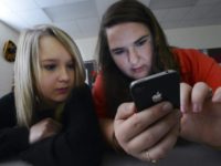Phones in School In this March 13, 2014 file photo, Hartselle High School students Lissa Blagburn and Brantlee Wright use an iPhone as they work on a networked lesson in Spanish class in Hartselle, Ala. Cellphones are still absent from most U.S. schools but new data shows them steadily gaining acceptance as administrators bow to parents' wishes to keep tabs on their kids and teachers find ways to work them into lessons. (Gary Cosby Jr./The Decatur Daily via AP, File) The Associated Press