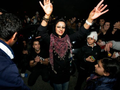 Between the people, a woman dances, in the Pardisan Park in Tehran, Iran, Tuesday, March 1