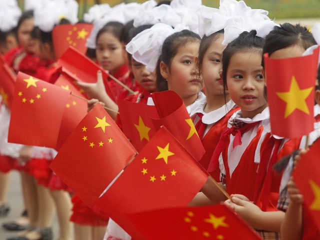 Young Vietnamese girls wave Chinese and Vietnamese flags as visiting Chinese vice president Xi Jinping (not pictured) is greeted during the official welcoming ceremony at the presidential palace in Hanoi on December 21, 2011. Xi is on a three-day official visit for talks with all top Vietnamese leaders on a …