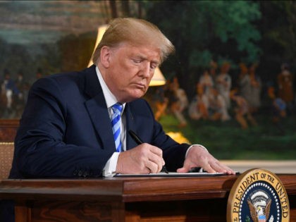 US President Donald Trump signs a document reinstating sanctions against Iran after announcing the US withdrawal from the Iran Nuclear deal, in the Diplomatic Reception Room at the White House in Washington, DC, on May 8, 2018. (Photo by SAUL LOEB / AFP) (Photo credit should read SAUL LOEB/AFP/Getty Images)