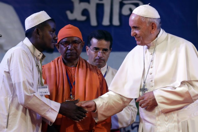 Pope Francis, right, shakes hands with a Rohingya Muslim refugee during an interfaith and