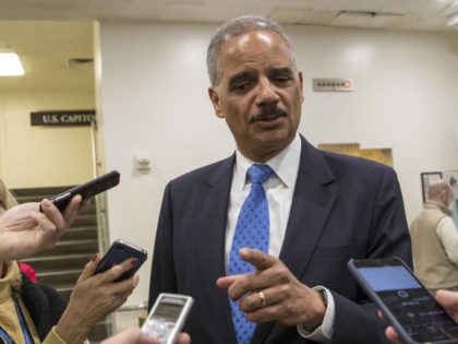 Former Attorney General Eric Holder takes questions from reporters at the Capitol where he
