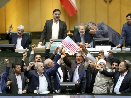 Iranian lawmakers burn two pieces of papers representing the U.S. flag and the nuclear deal as they chant slogans against the U.S. at the parliament in Tehran, Iran, Wednesday, May 9, 2018. Iranian lawmakers have set a paper U.S. flag ablaze at parliament after President Donald Trump's nuclear deal pullout, …