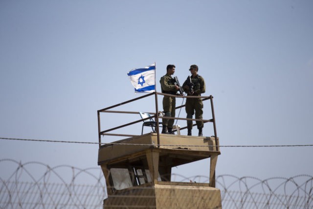 Israeli soldiers guard on top of a watch tower in a community along the Israel- Gaza Strip