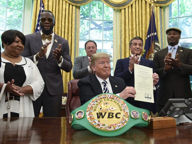 President Donald Trump center, posthumous pardons Jack Johnson, boxing's first black heavyweight champion, during an event in the Oval Office of the White House in Washington, Thursday, May 24, 2018. Trump is joined by, from left, Linda Haywood, who is Johnson's great-great niece, heavyweight champion Deontay Wilder, Keith Frankel, Sylvester …