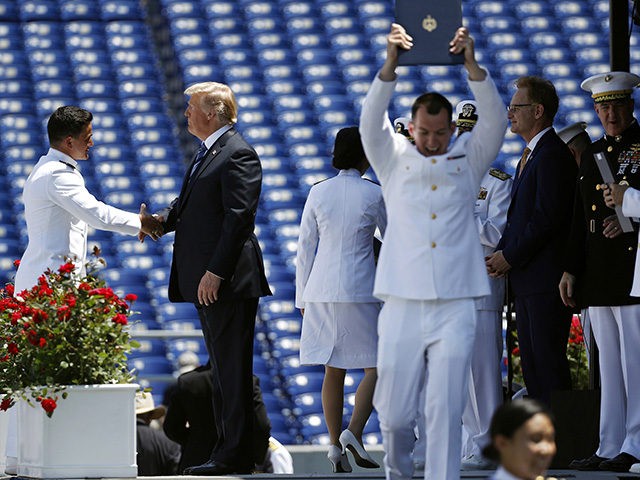 President Donald Trump shakes hands with a graduating U.S. Naval Academy midshipman during