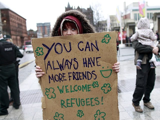A person joins the counter demonstration as they protest at the arrival of Anti-refugee rally outside Belfast city hall, Northern Ireland, Saturday, Dec. 5, 2015. The anti-refugee protest was made up of mainly Loyalist supporters and was organized ahead of the arrival on December 12th of Syrian refugees to Northern …