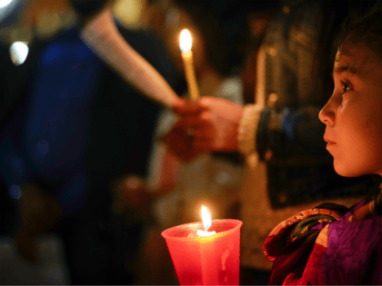 People hold candles as they attend a prayer vigil for terminally ill toddler Alfie Evans,