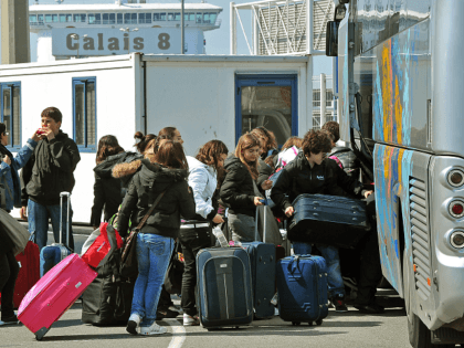 Travellers load their luggage onboard a bus before boarding a ferry to Dover on April 17,