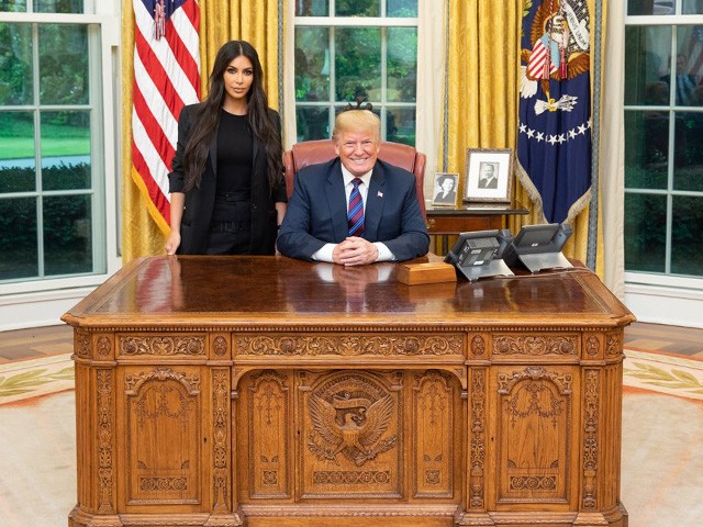 Donald Trump and Kim Kardashian in the White House. Both are behind the Oval Office's Resolute Desk.