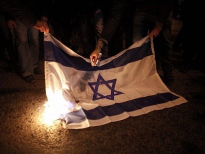 Illustrative photo of protesters burning an Israeli flag during a protest against Israel's attacks of the Gaza Strip. (AP/Kostas Tsironis)