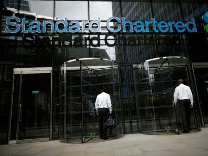 LONDON, ENGLAND - AUGUST 07: People enter the Standard Chartered bank's offices on August 7, 2012 in London, England. Standard and Chartered has been accused by American financial investigators of making billions of pounds worth of transactions with the Iranian regime, despite strict economic sanctions being in place. (Photo by …