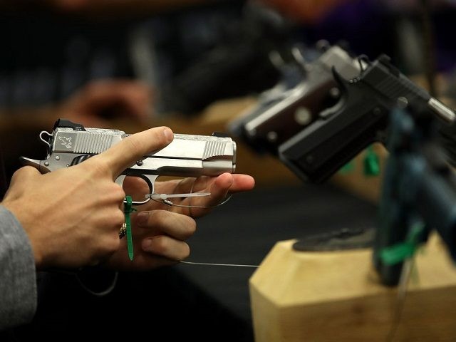 An attendee inspects a handgun during the NRA Annual Meeting & Exhibits at the Kay Bailey Hutchison Convention Center on May 5, 2018 in Dallas, Texas. The National Rifle Association's annual meeting and exhibit runs through Sunday. (Photo by Justin Sullivan/Getty Images)