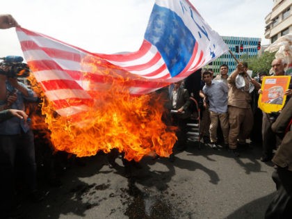 TOPSHOT - Iranians set fire to a makeshift US flag during a demonstration after Friday prayer in the capital Tehran on May 11, 2018. - Iran's foreign minister will embark on a diplomatic tour to try to salvage the nuclear deal amid high tensions following the US withdrawal and global …
