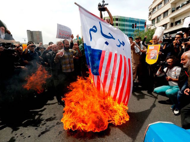 Iranian protesters burn a US flag as they hold anti-US placards and shout slogans during a demonstration after Friday prayer in the capital Tehran on May 11, 2018. - Iran's foreign minister will embark on a diplomatic tour to try to salvage the nuclear deal amid high tensions following the …