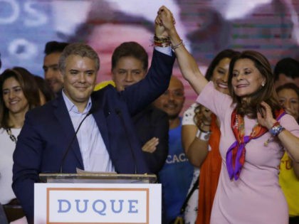 Ivan Duque, presidential candidate for the Democratic Center, left, and his vice presidential formula Marta Lucia Ramirez raise arms after winning the first round presidential election in Bogota, Colombia, Sunday, May 27, 2018. With almost all polling stations reporting, Duque won 39 percent trailed by leftist former leftist rebel and …