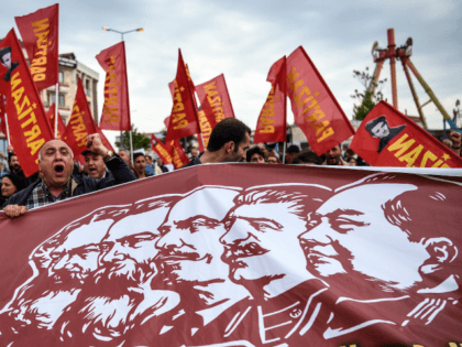 People hold a banner picturing Communist figures including (From L) …
