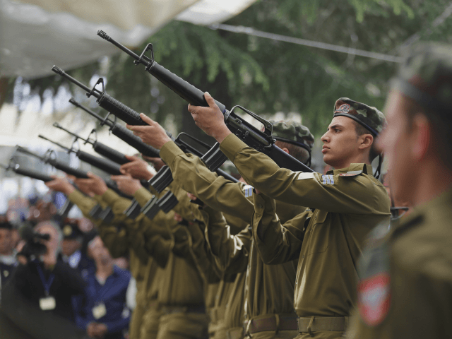 Israeli soldiers fire a gun salute during a Memorial Day ceremony to commemorate the country's fallen soldiers, at Mount Herzl military cemetery in Jerusalem, Wednesday, April 22, 2015. (Ammar Awad/Pool photo via AP)