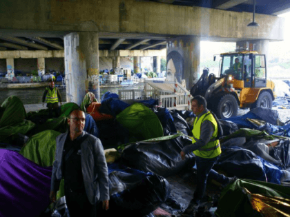 Paris town hall workers clear a migrant makeshift camp, in Paris, Wednesday, May 30, 2018.