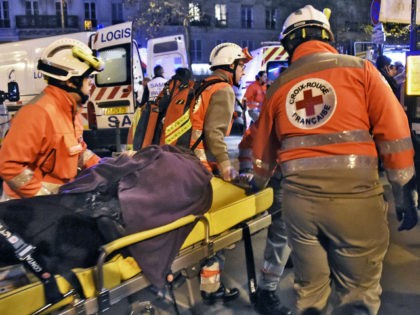 Rescue workers evacuate an injured person near the Bataclan concert hall in central Paris,