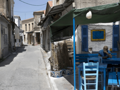 A man sits on a chair of a closed coffee …