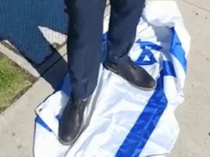 Patrick Little stands on Israeli flag (Screenshot / Bitchute)