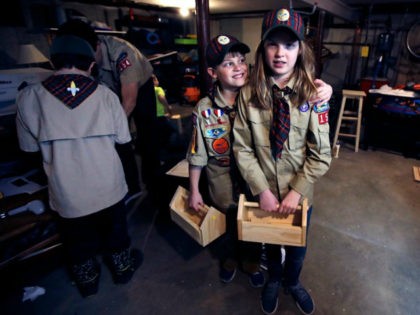 In a Thursday, March 1, 2018 photo, Tatum Weir, right, poses with her twin brother Ian, left, after a cub scout meeting where they each built a tool box in Madbury, N.H. Fifteen communities in New Hampshire are part of an "early adopter" program to allow girls to become Cub …