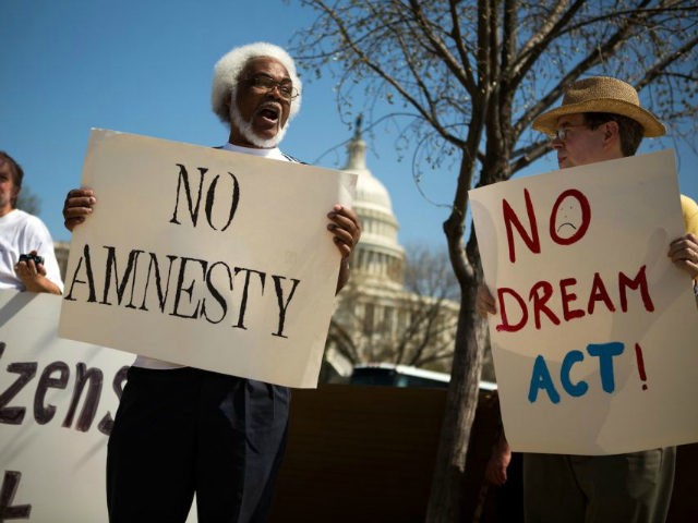Tabu Henry Taylor (C) of Washington DC, and Mike Crowe (R) of Springfield, Virginia, join a handful of protesters from anti-amnesty groups, including New Yorkers for Immigration Control and Enforcement (NY ICE) and The Tea Party Immigration Coalition, to demonstrate in front of the U.S. Capitol building April 10, 2013 …