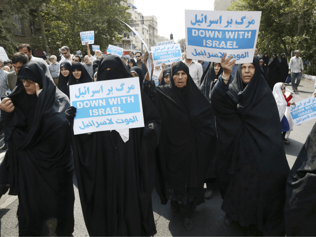 Iranian women hold anti-Israeli placards at a protest after Friday prayer service in Tehra