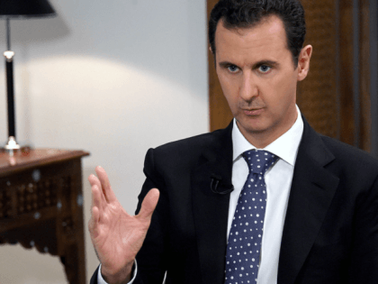 Syrian President Bashar al-Assad gestures during an exclusive interview with AFP in the ca