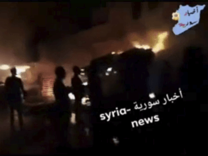 This frame grab from video provided on Wednesday, May, 9, 2018 by Syria News, shows people standing in front of flames rising after an attack on an area known to have numerous Syrian army military bases, in Kisweh, south of Damascus, Syria on Tuesday. The Britain-based Syrian Observatory for Human …