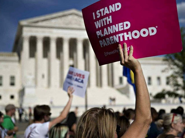 A demonstrator opposed to the Senate Republican health-care holds a sign that reads 'I Stand With Planned Parenthood' while marching near the U.S. Supreme Court in Washington, D.C., U.S., on Wednesday, June 28, 2017. Several Senate Republicans began to question today whether their health-care bill should repeal a tax on …