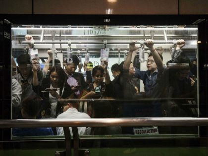 Passengers use smartphones while riding on a subway train in Shanghai, China, on Friday, O